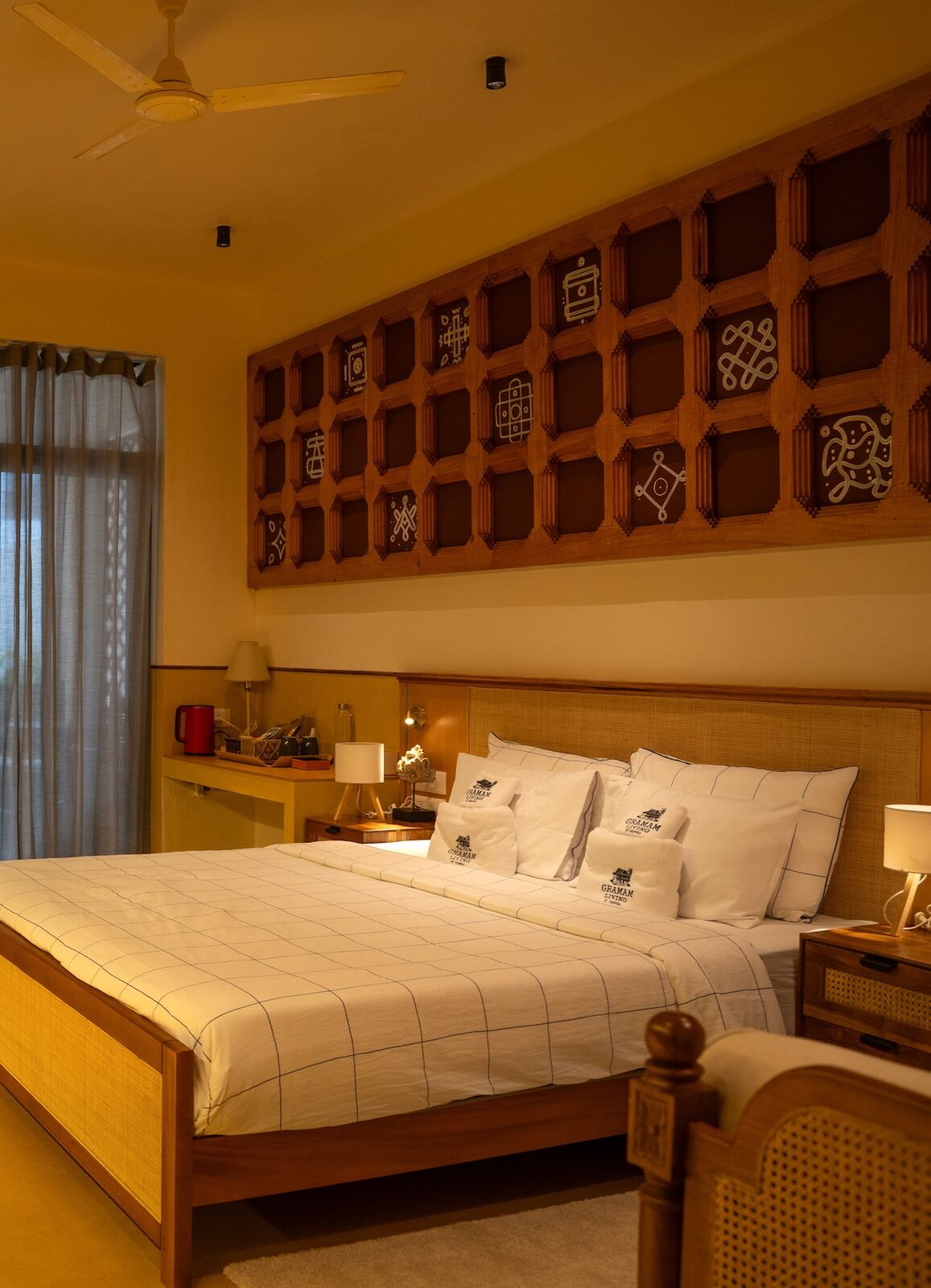Bedroom one, a king bed against a carved lattice headboard.