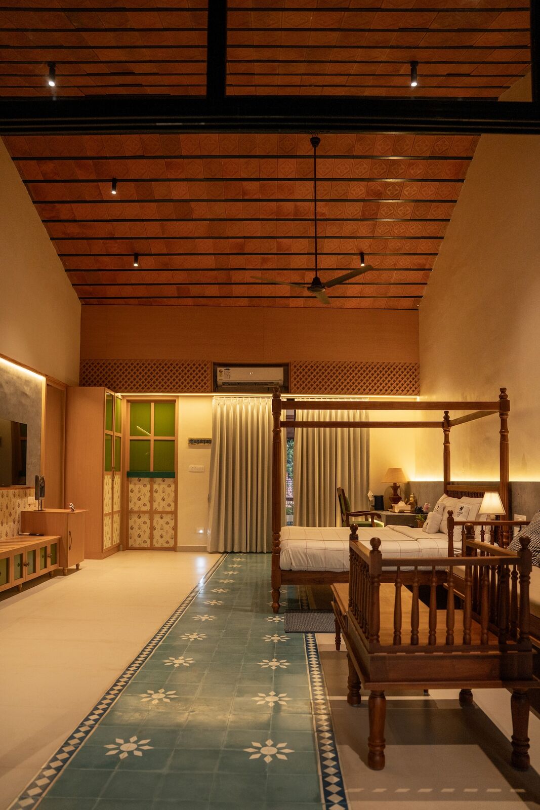 Bedroom two, a teak four-poster under a pitched tile ceiling.